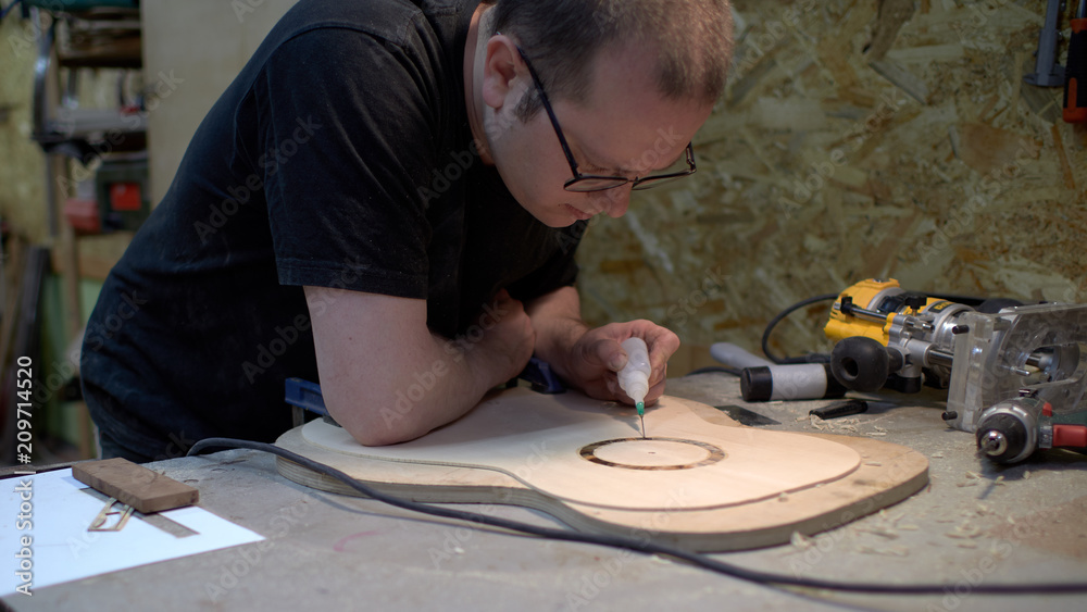 The guitar master pastes the rosette into a classical guitar. The guitar master pastes the rosette into a classical guitar.