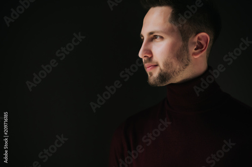 Portrait of a young man. Male studio portrait with cinema light and dark backdrop.bachelor