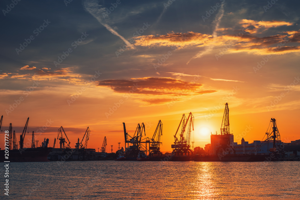 Obraz premium Sunset over sea port and industrial cranes, Varna