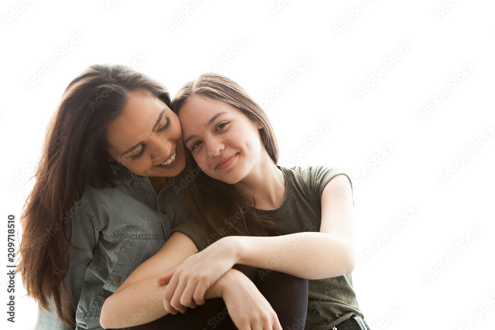 Portrait of two sisters next to a big bright window. Happy family Portrait of two sisters next to a big bright window. Happy family