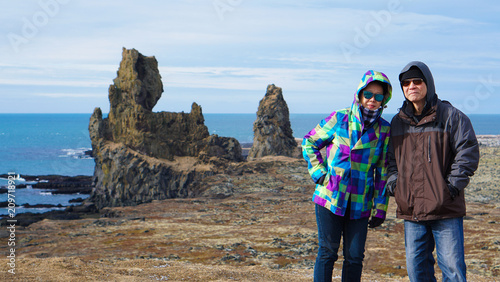 Asian senior couple travel photo with Iceland pennisula rock landmark photo