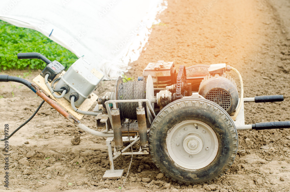 Obraz premium electric winch or cultivator for of agricultural work, farming, cultivation, agro-industry, the chain mechanism and gear