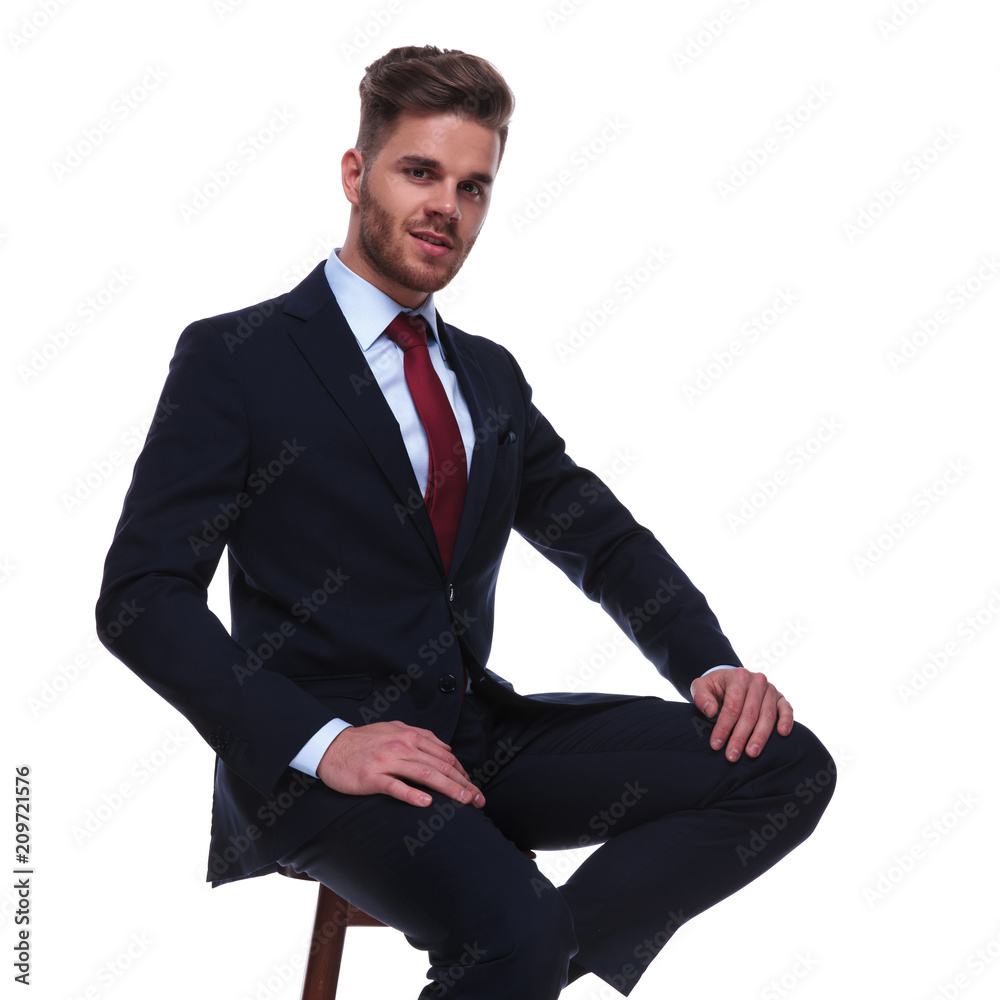 attractive businessman in navy suit resting on wooden chair attractive businessman in navy suit resting on wooden chair