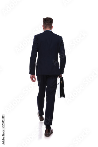 back view of stepping businessman with briefcase in hand