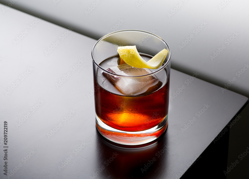 Cocktail with large ice cube and lemon twist Stock Photo