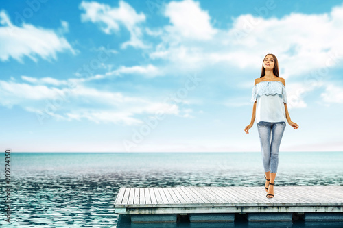 Summer time and slim woman on pier. Sea landscape with blue sky.  © magdal3na