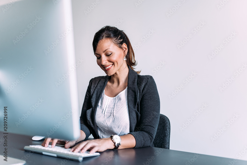 Smiling businesswoman at office desk. Smiling businesswoman at office desk.
