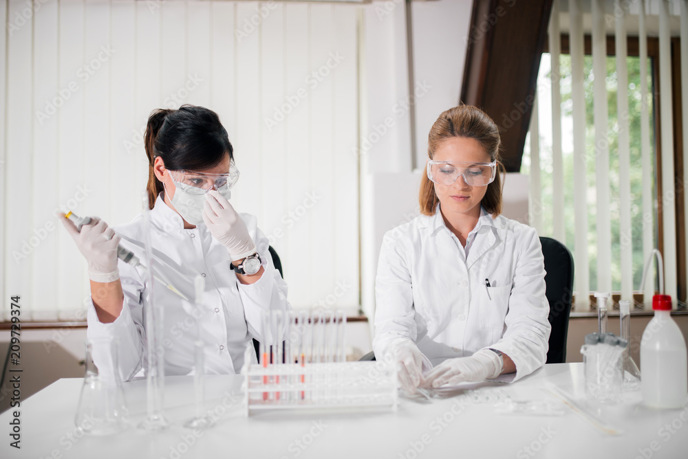 Two female researchers doing water test contamination in the laboratory. Two female researchers doing water test contamination in the laboratory.