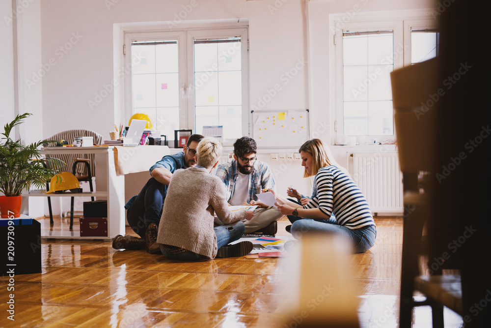 Fotografie Creative team is trying to develop new ideas while sitting on a floor in a inspiring room