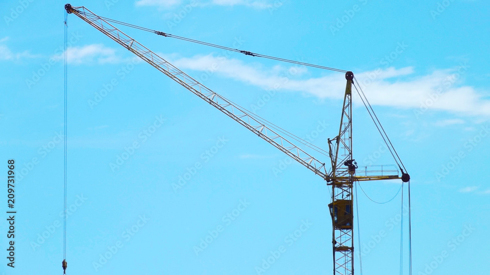 Construction site.Crane on the background of the blue sky. Construction site.Crane on the background of the blue sky.