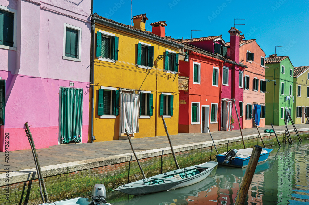 Panoramic view of colorful buildings and boats in front of a canal at Burano, a gracious little town full of canals, near Venice. In the Veneto region, northern Italy