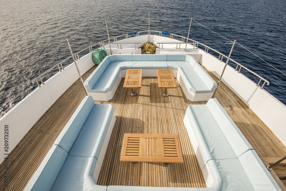 Table and chairs on bow deck of a luxury motor yacht - obrazy, fototapety, plakaty 