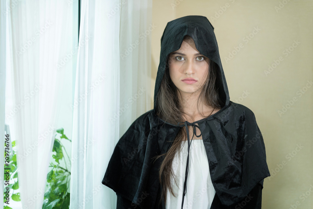 Beautiful and serious young witch looking at camera.