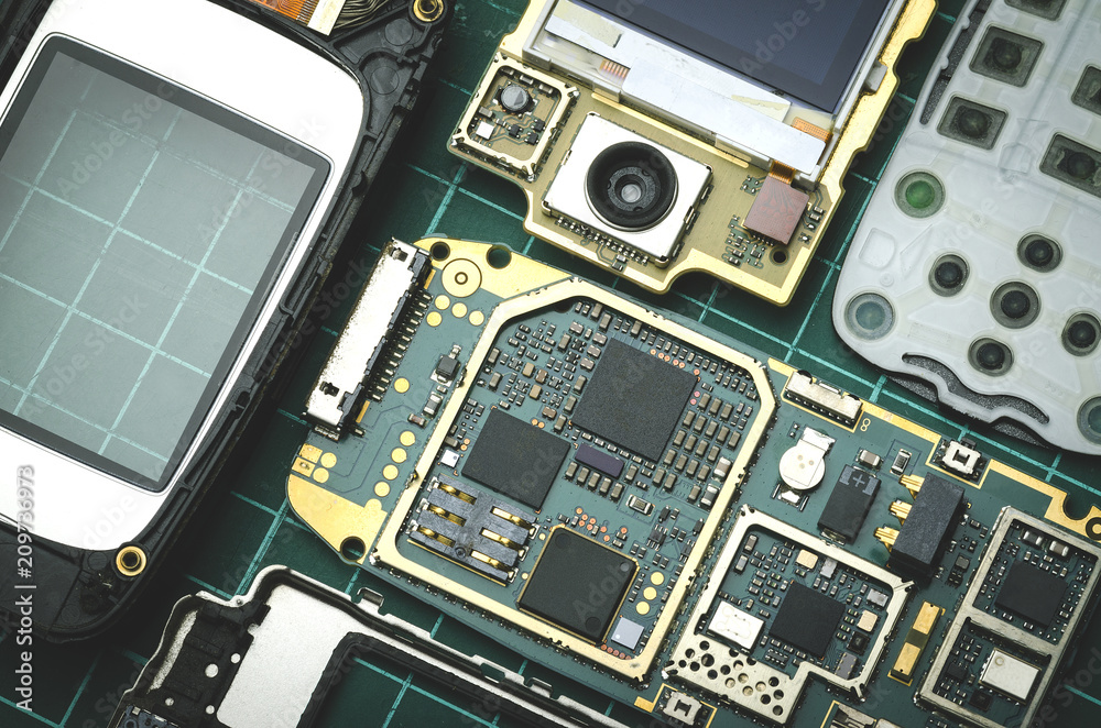 Fototapeta premium Components of old mobile phone close-up on green background
