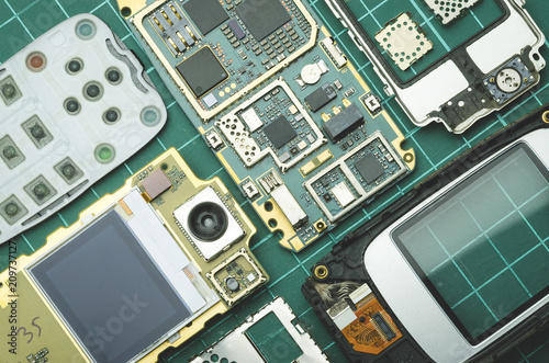 dismantled for spare parts old mobile phone on green background close-up