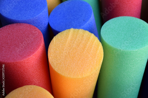 different colors pool noodles, therapy or aqua gym noodle macro shot