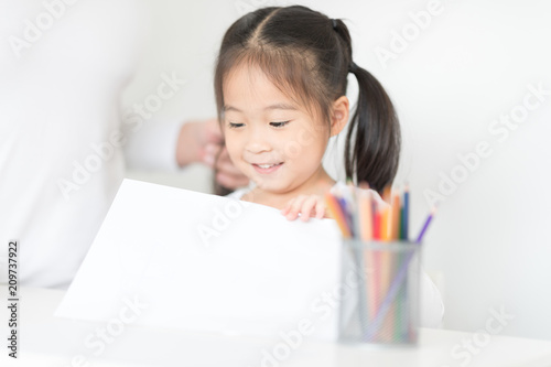Cute Asian girl was smiling for her homework is success by herself.