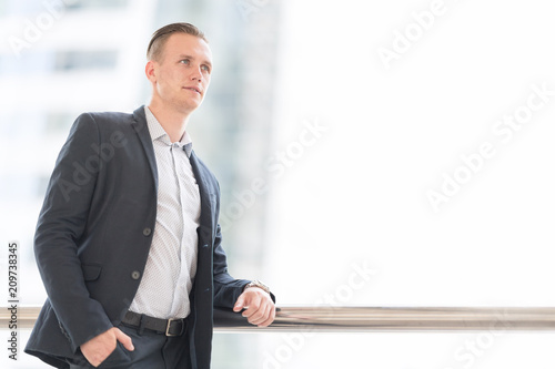 Handsome and Confident Businessman wear Jecket Suit with Blurred City Center. Successful Young Business People Lifestyle Concept.