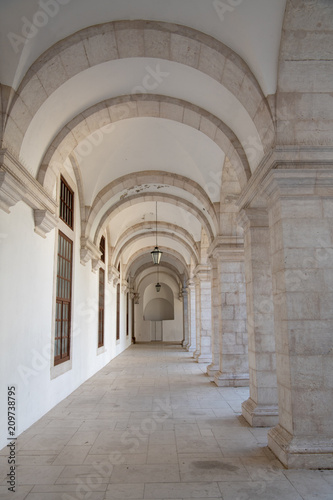 Walkway moving towards perspective through cloister and arches at Igreja e Convento da Graca in Lisbon, Portugal