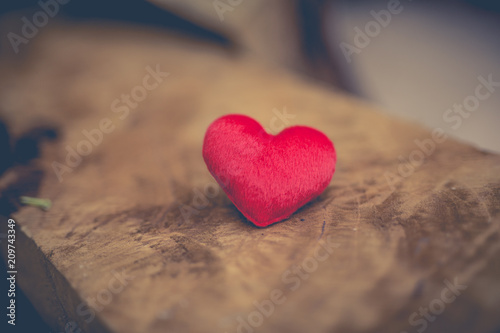 Red heart shape on wooden board.