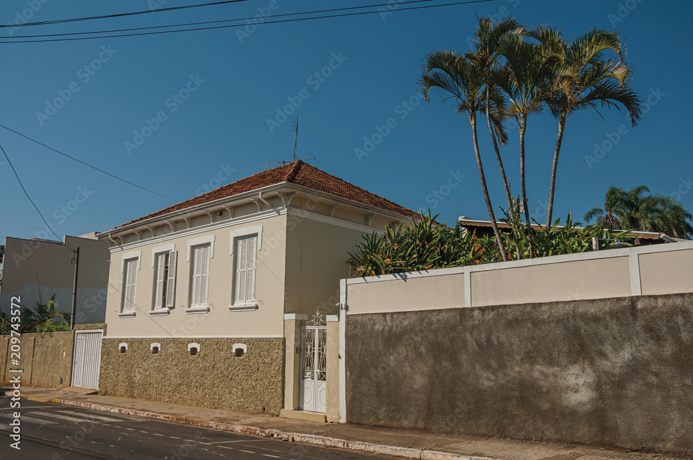 Working-class old house with wall in an empty street on a sunny day at São Manuel. A cute little town in the countryside of São Paulo State, southeast Brazil