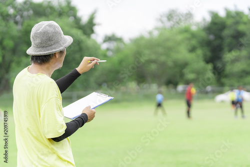 Football or socker coach observing kid football match.Healthy sport concept.
