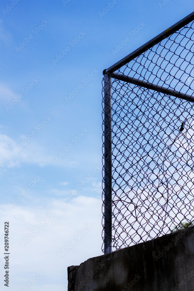 mesh fence with blue sky.