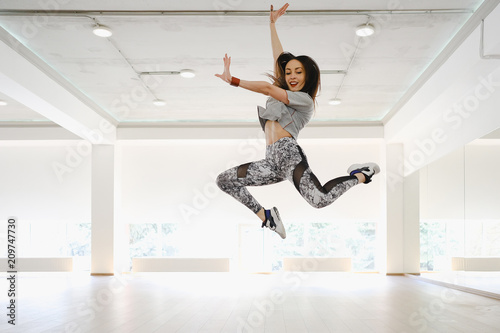 Athletic young girl performing sports and dance alone in a studi