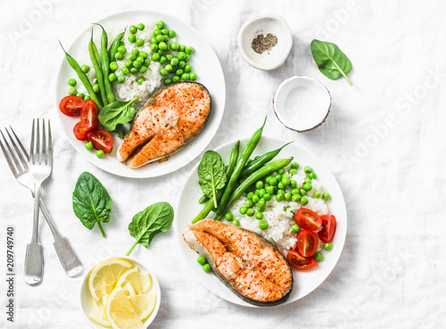 Smoked paprika baked salmon, rice, green peas and green beans on a light background, top view. Flat lay. Healthy balanced mediterranean diet lunch