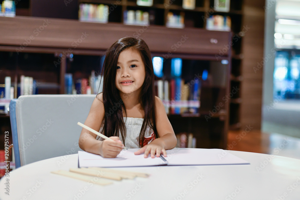 Education Concepts. The girl is studying in the library. Beautiful girls are happy learning. Education Concepts. The girl is studying in the library. Beautiful girls are happy learning.