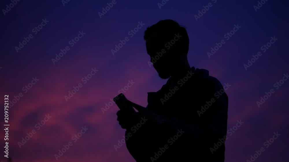 silhouette of a man with a mobile phone in his hands silhouette of a man with a mobile phone in his hands