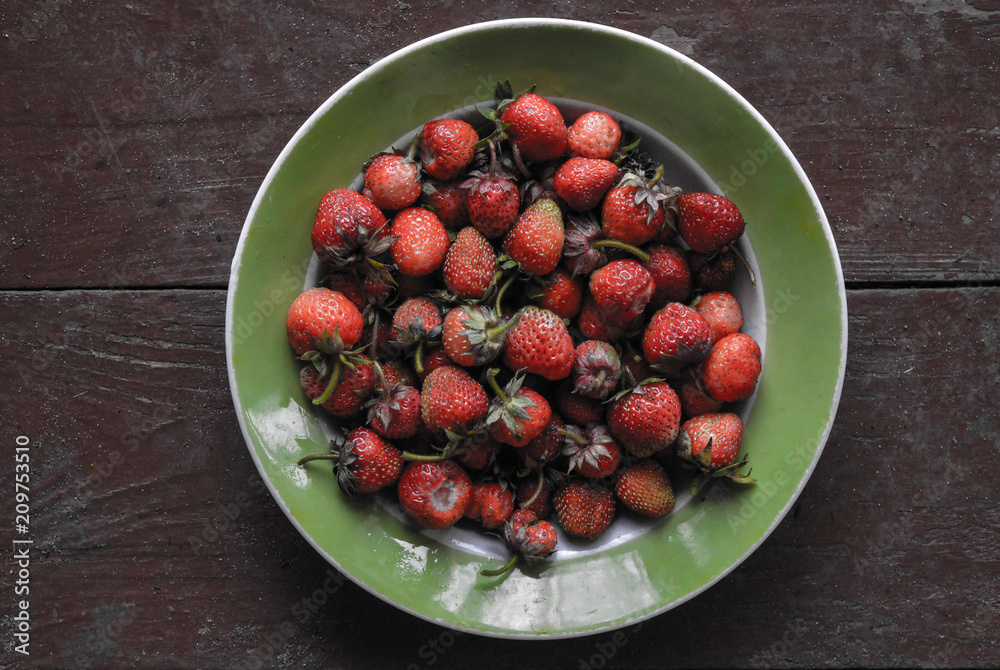 Strawberries in a plate on a wooden background Strawberries in a plate on a wooden background