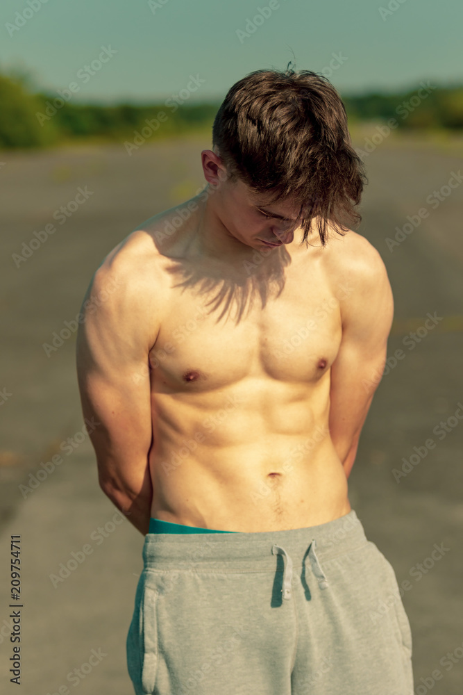Fototapeta premium Young adult male shirtless outdoors