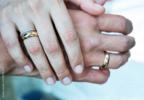 The hands of the husband and wife are linked by the little fingers