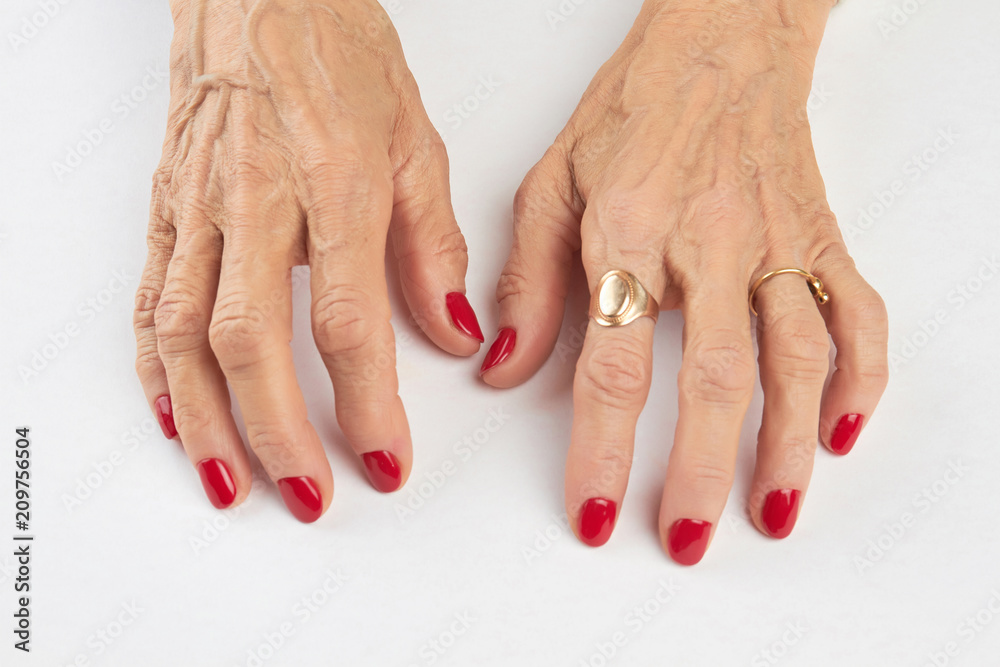 Manicure with red nails on white background. Close up of hands of old woman  with short red manicure on nails isolated on white background. Beautiful red  manicure on female hands. Photos