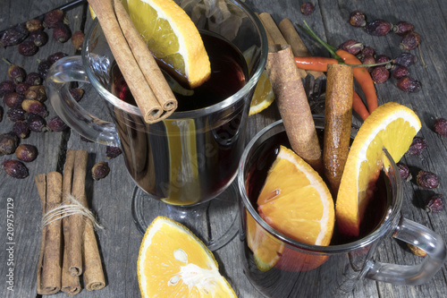 glasses of mulled wine with orange and cinnamon on a wooden background