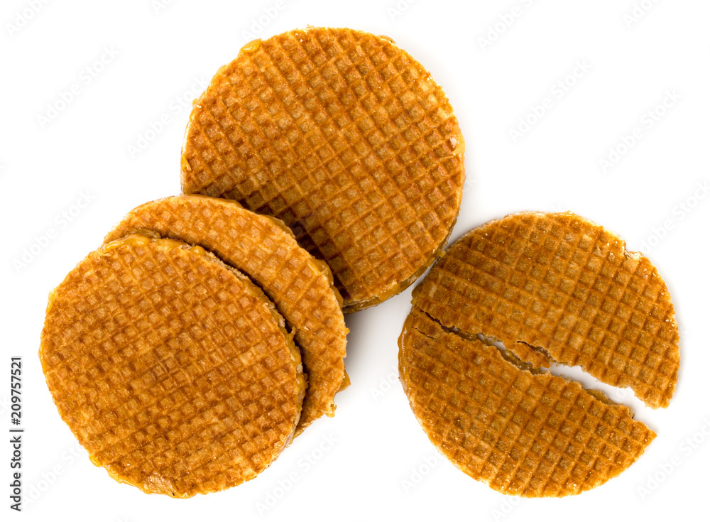 Dutch waffles and wafers broken in half on a white. The view from the top.