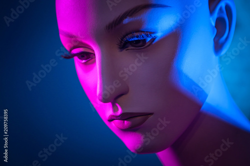 Portrait of a mannequin woman. Artificial face. Profile of a woman's face. The woman's face is in red light. Mannequin woman. Close-up portrait. Female profile.