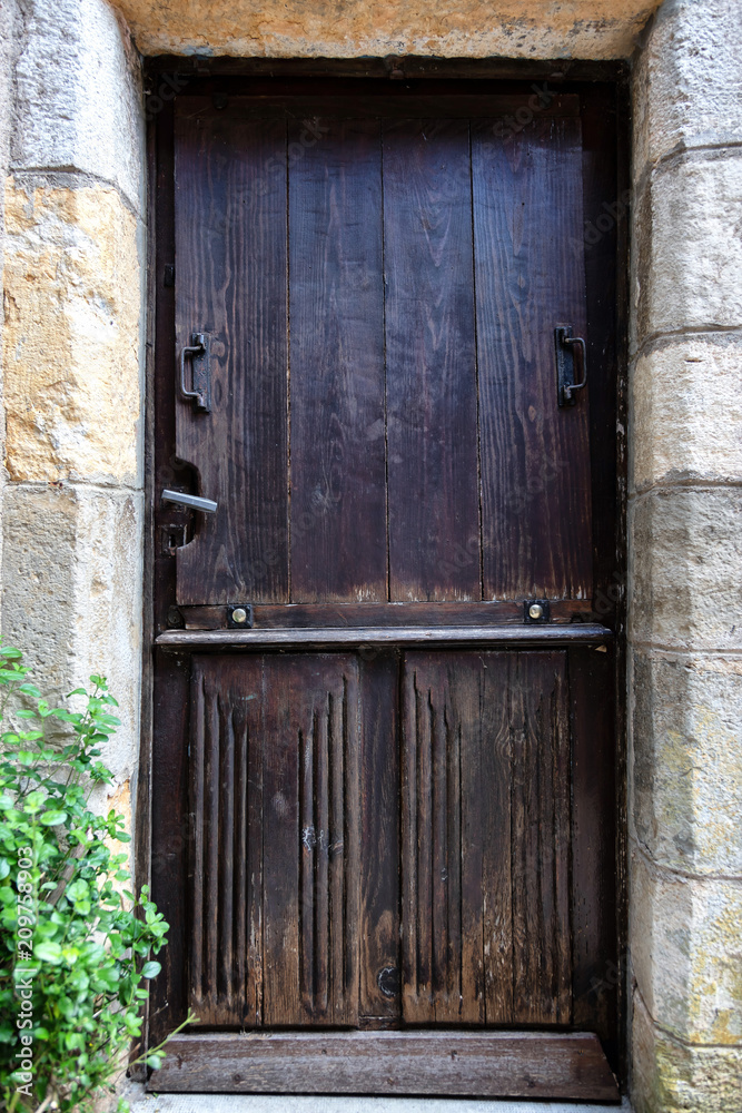 Vieille porte médiévale en bois dans un mur de pierre Vieille porte médiévale en bois dans un mur de pierre