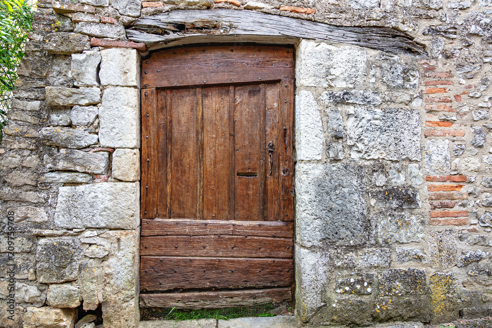 Vieille porte médiévale en bois dans un mur de pierre