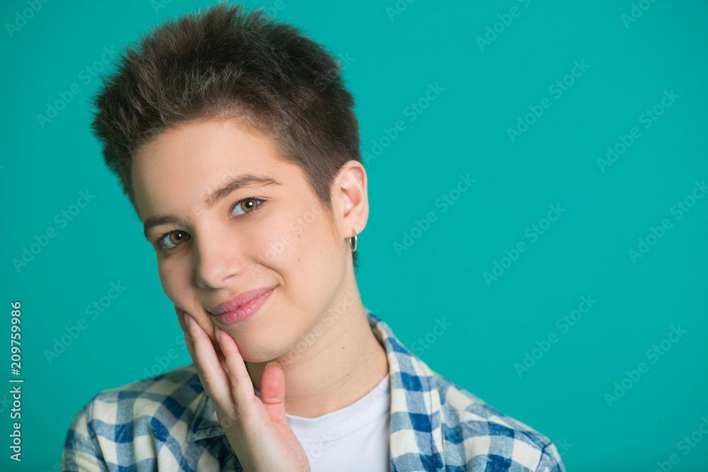 beautiful young girl with short hair in a shirt on a blue background