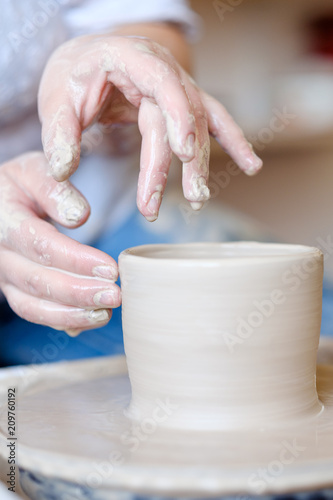 handmade hobby pottery courses. master class at workshop. potter forming clay on turning wheel