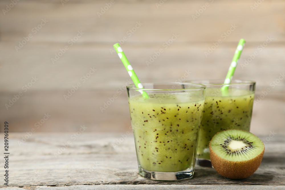 Fresh kiwi smoothie in glass on grey wooden table Fresh kiwi smoothie in glass on grey wooden table
