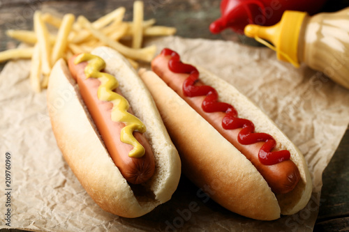 Canvas-taulu Hot dogs with mustard and ketchup on wooden table