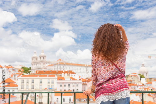 Girl admiring rooftops of Alfama in Lisbon Portugal photo