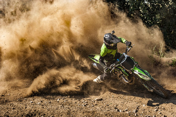 Fototapete Motorsport Motocross-Fahrer erzeugt eine große Staub- und Schmutzwolke  © KopoPhoto