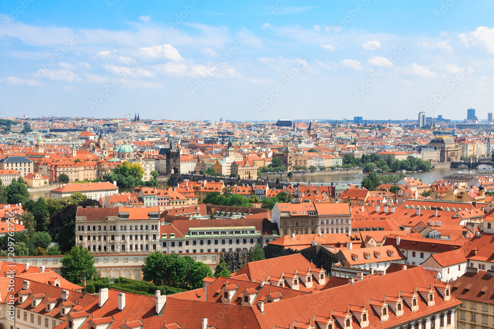 Beautiful and ancient city of Europe - Prague, Czech Republic. View of the city from the observation deck. Small houses and the river Vltava. Charles Bridge and temples.