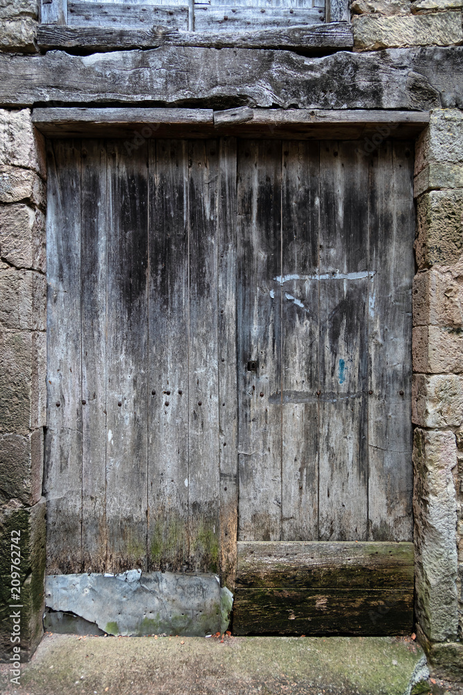 Fototapeta premium Vieille porte médiévale en bois dans un mur de pierre