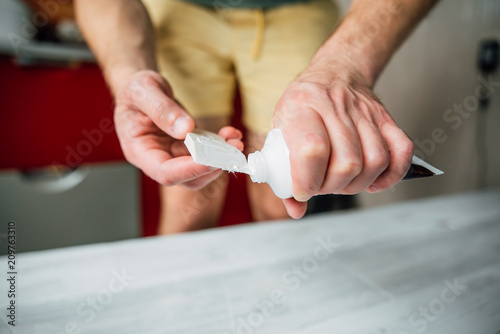 Putty in the hand of a person. Removing paint from the surface of the tree. Preparation of boards before impregnation with varnish. Application of putty.