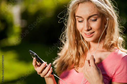 girl talking on the phone in the Park with headphones